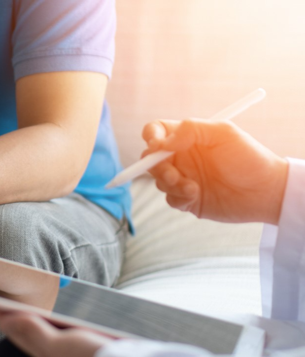 A healthcare professional holding a thermometer in focus, with a patient in the background, illustrating our Hobart-based supervision services for developing healthcare expertise.